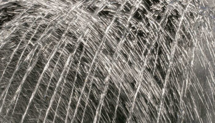 What kind of lens does a water droplet in air act like?