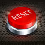 Where is the reset button located on the atomic clock?