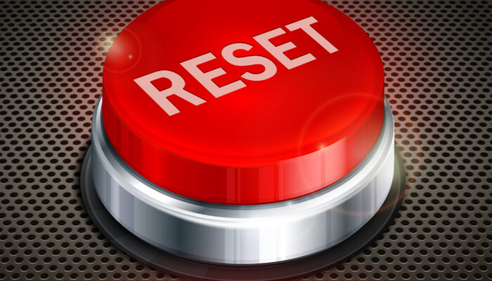 Where is the reset button located on the atomic clock?